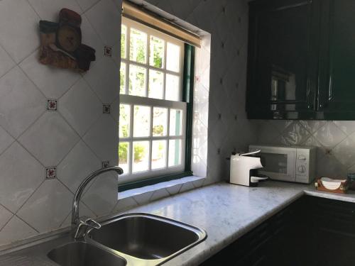 una cucina con lavandino e finestra di Quinta do Ladário a Várzea Ovelha e Aliviada