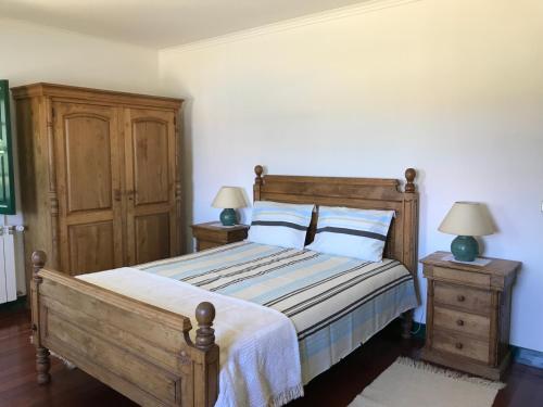 a bedroom with a wooden bed and two night stands at Quinta do Ladário in Várzea Ovelha e Aliviada
