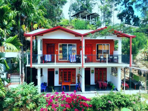 a red and white house with a balcony at Pearl View Guesthouse in Ella