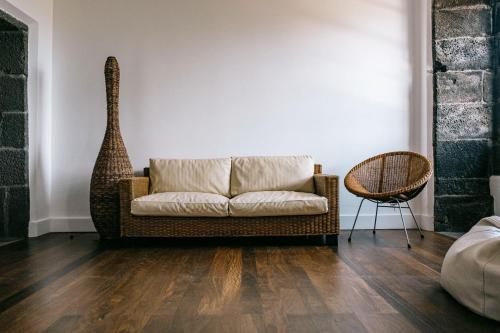 a living room with a couch and a chair at Azores Youth Hostels - Pico in São Roque do Pico