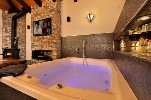 a large bath tub with two glasses of wine at Noam Suites in Bruchim Qela' Alon