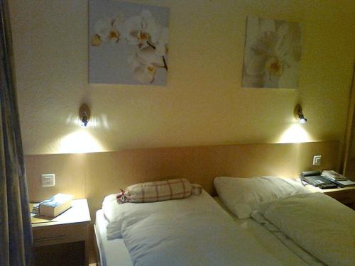 a bedroom with two beds and two lights on the wall at Hotel Sherlock Holmes & Khana Restaurant "200 m Gondola to Hasliberg ski" in Meiringen