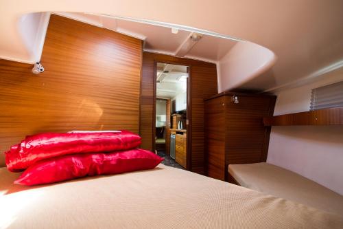 a bedroom with two red pillows on a bed at Jacht motorowy Nautika 1000 in Wilkasy