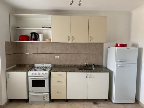 uma cozinha com electrodomésticos brancos e um frigorífico branco em Dpto Alquiler Temporario em Corrientes