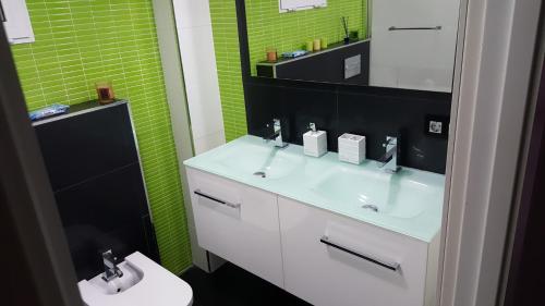 ein Badezimmer mit einem Waschbecken, einem Spiegel und einem WC in der Unterkunft Moderno apartamento en el parque de cabecera in Valencia