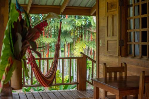 a room with a table and a hammock in front of a window at Casa Viva Eco Lodge in Puerto Viejo