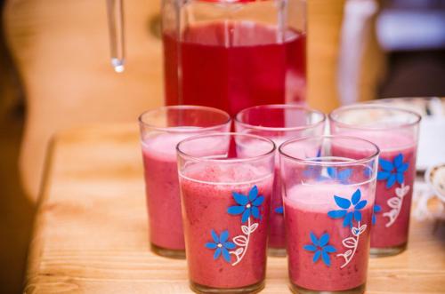 a group of four glasses filled with pink liquid at Хата Різьбяра in Beloberëzka
