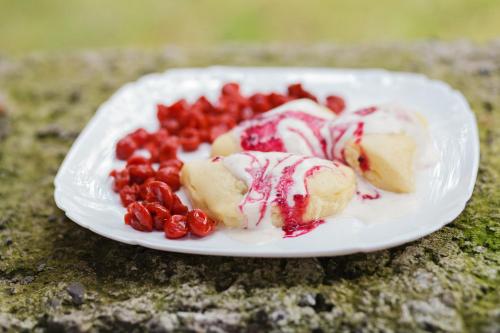 a plate of food with fruit on a table at Хата Різьбяра in Beloberëzka