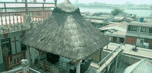 sombrilla de paja en la parte superior de un balcón en Benin Hotel Terminus, en Cotonou