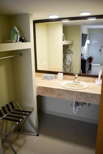a bathroom with a sink and a mirror at El Camino Hotel & Suites in Heroica Caborca