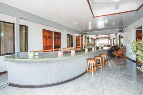 a lobby with a long bar with stools at Hotel Hoja de Oro Corcovado in Puerto Jiménez