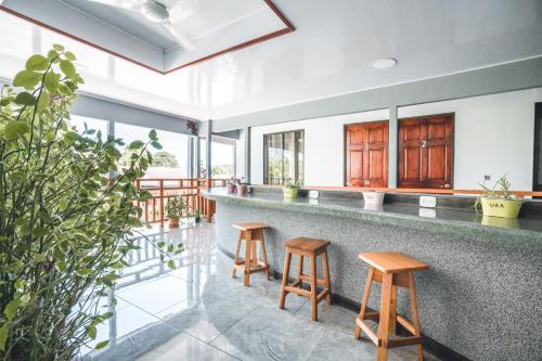 a kitchen with a bar with two stools at Hotel Hoja de Oro Corcovado in Puerto Jiménez
