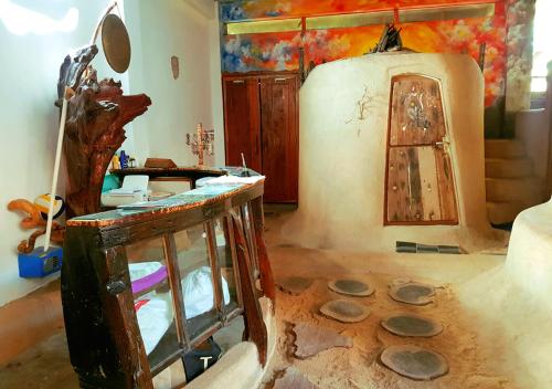 a living room with a painting and a refrigerator at The Rabbit Tree Hostel in Gili Meno