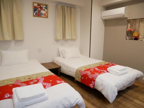 a room with two beds with towels on them at Tokyo shinjukutei Hotel Asahi gruop 東京新宿亭ホテル in Tokyo