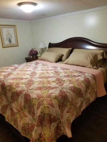 1 dormitorio con 1 cama grande con colcha de flores en Cheap East Knoxville Basement Studio en Knoxville