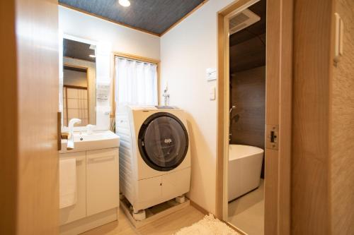 a bathroom with a sink and a washing machine in it at 照宿 Terasu yado in Aira