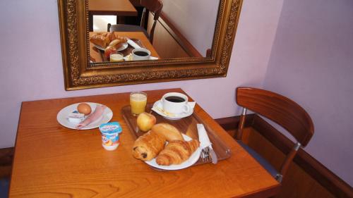 a table with a tray of pastries and a mirror at Hotel De La Rade in Brest