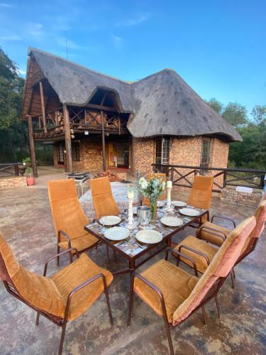 a table and chairs in front of a building at Kruger River View in Marloth Park