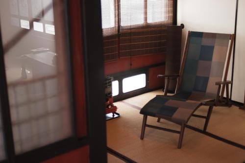 a room with a chair and a window at 一棟貸ゲストハウス 傾㐂屋 Kabukiya in Hiroshima