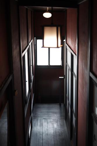 an empty hallway with a door and a window at 一棟貸ゲストハウス 傾㐂屋 Kabukiya in Hiroshima