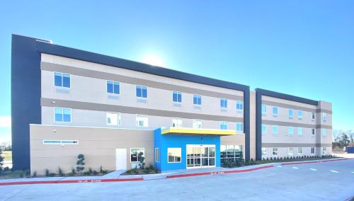 a large office building with a parking lot at Days Inn by Wyndham Beaumont West I-10 Walden in Beaumont