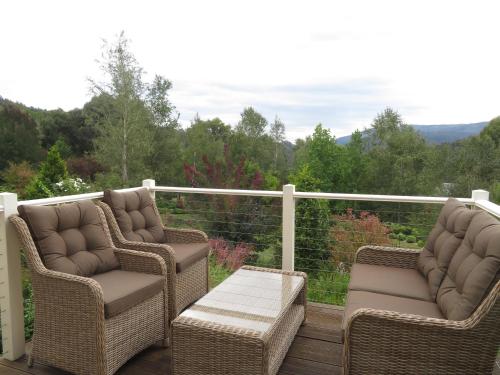 two wicker chairs and a table on a deck at Delderfield Villas Adults Retreat in Marysville