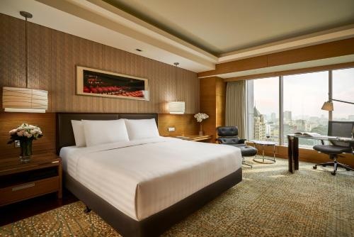 a hotel room with a bed and a desk and a window at InterContinental Saigon, an IHG Hotel in Ho Chi Minh City