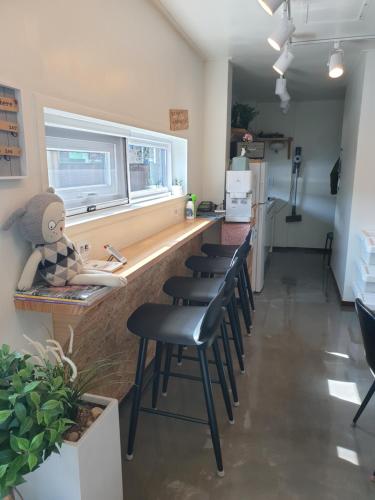 a kitchen with a counter with stools in a room at Sokcho Hutte in Sokcho