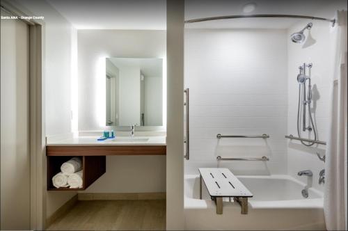 a bathroom with a tub and a sink and a shower at Holiday Inn Express & Suites Santa Ana - Orange County by IHG in Santa Ana