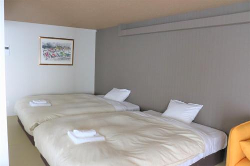 two beds sitting next to each other in a room at Stay's OTARU in Otaru