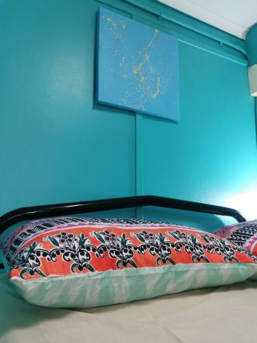a bed in a room with a blue wall at Darwin Hostel in Darwin