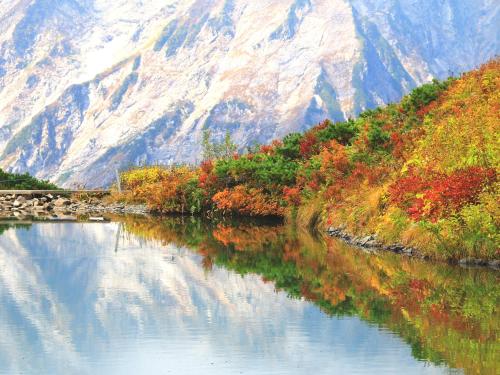 a body of water with a mountain in the background at Hotel Grace Hakuba in Hakuba