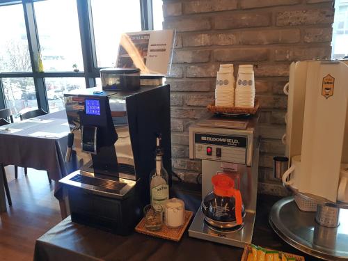 a counter with a coffee maker and a bottle of wine at Vella Suite Hotel in Suwon