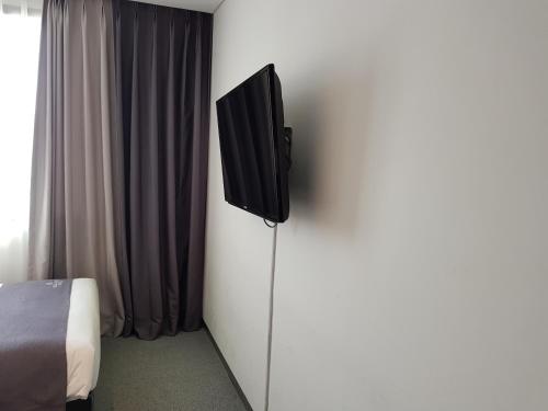 a television on a wall in a bedroom at Vella Suite Hotel in Suwon