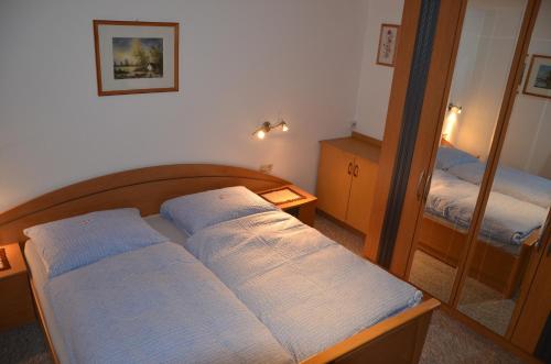 a small bedroom with a bed and a mirror at Ferienwohnung Garber in Uderns