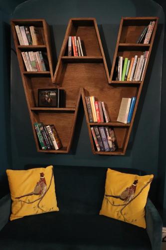 a book shelf with books on top of a wall at Wisteria Hotel in Oakham