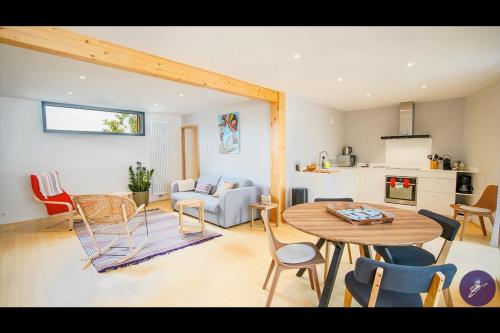 uma cozinha e sala de estar com mesa e cadeiras em Cap Away I Appart Hotel em Andernos-les-Bains