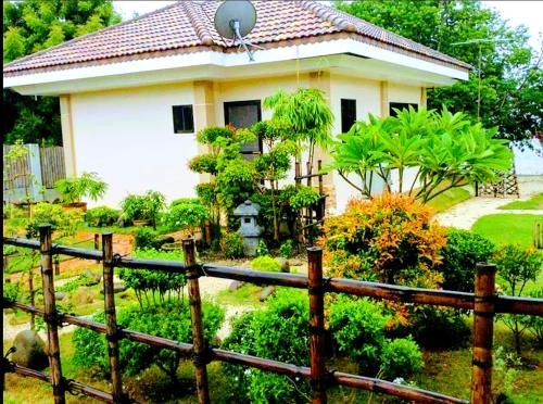 a house with a fence in front of a garden at Adayo Cove Resort in Siquijor