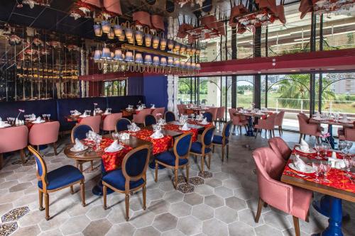 Un comedor con mesas y sillas y ventanas. en Greenwood Suites Resort, en Lara