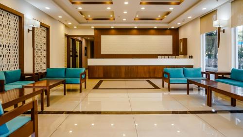 a waiting room with blue chairs and a projection screen at The Altruist Navi Mumbai Hotel in Navi Mumbai