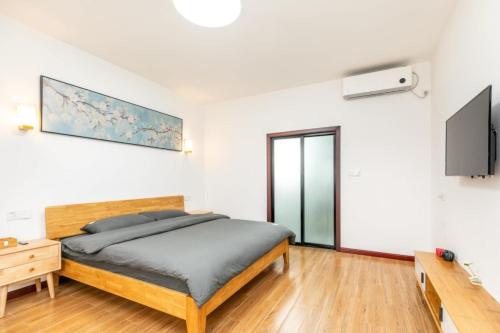 a bedroom with a bed and a tv on the wall at CSDY House in Shanghai