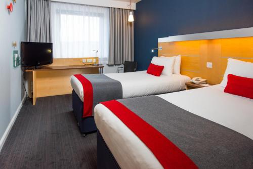 a hotel room with two beds and a flat screen tv at Holiday Inn Express Hemel Hempstead, an IHG Hotel in Hemel Hempstead