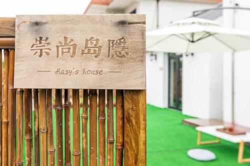 a sign on a wooden fence with a green floor at CSDY House in Shanghai