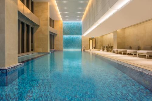 a swimming pool in a building with blue water at Crowne Plaza Macau, an IHG Hotel in Macau