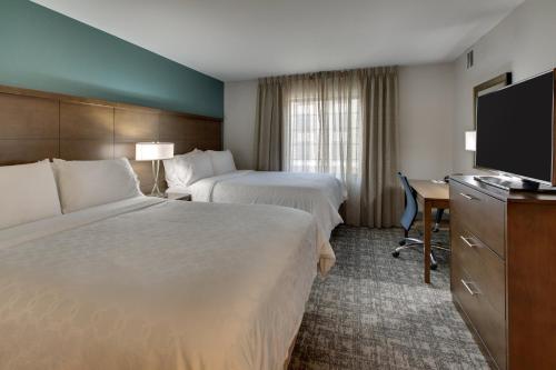a hotel room with two beds and a flat screen tv at Staybridge Suites Missoula by IHG in Missoula