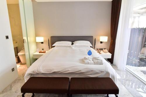 a large white bed with two cats laying on it at Volando Kenting in Hengchun
