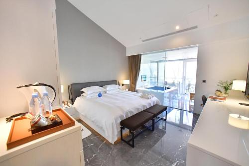 a bedroom with a bed and a desk with a lamp at Volando Kenting in Hengchun