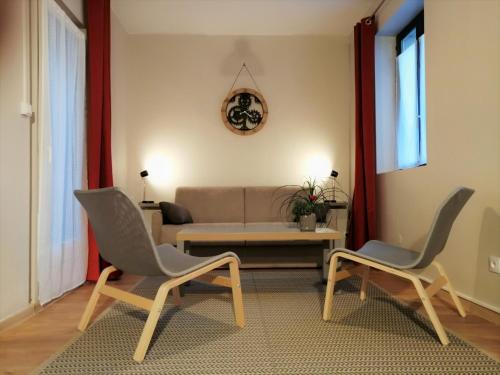 a living room with two chairs and a couch at Gite Côté Cour Colmar in Colmar