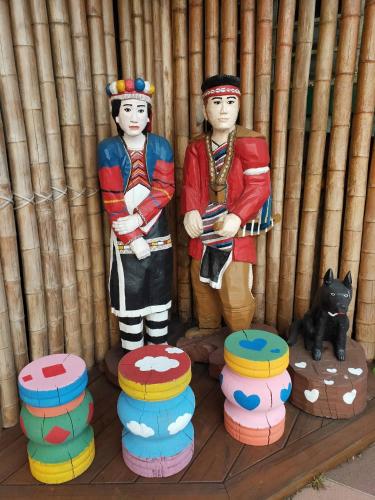 two wooden statues of people standing next to a cat at 悟 佐茶 Satori tea in Leye