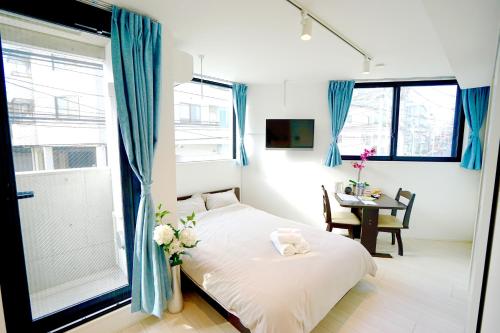 a small bedroom with a bed and a table at Court Residence Tokyo Nakano in Tokyo